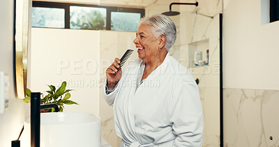 Buy stock photo Senior woman, singing and brush in bathroom with music, getting ready and karaoke concert. Elderly person, sound and comb for fun entertainment, grooming routine and playlist for performance at house