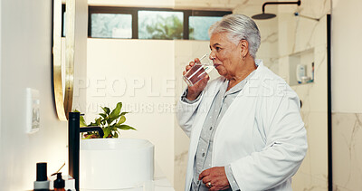 Buy stock photo Drinking water, morning and senior woman in bathroom, thirsty and wellness with retirement. House, pensioner and elderly person with glass, liquid and hydration with nutrition, healthy and start day