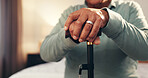 Senior hands, cane and recovery in home for injury, stroke or osteoporosis in bedroom for retirement. Elderly person with disability, walking stick or crutch for mobility, balance and rehabilitation