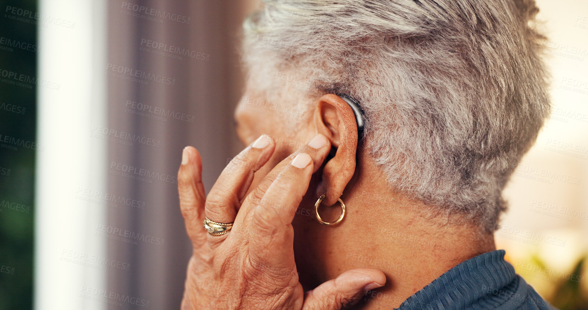 Buy stock photo House, back and senior woman with hearing aid, testing and fitting mould with retirement. Hand, pensioner and elderly person with disability, medical audio tech and deaf with technology and support