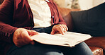 Hands, reading and senior woman with bible in home for worship, faith and spiritual wellness. Christian, religion and elderly female person with studying holy book for learning gospel in living room.