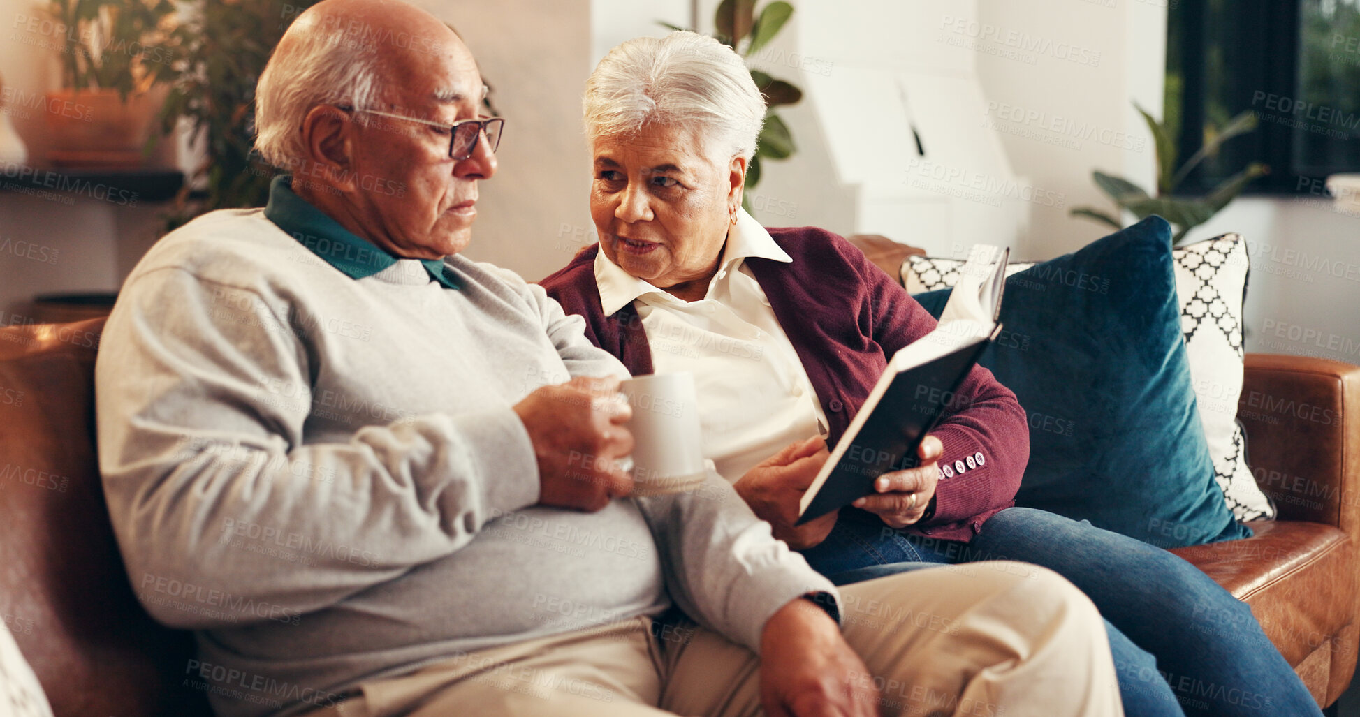 Buy stock photo Home, bible study and old couple on sofa, support and religion with relationship, worship and talking. Apartment, pensioner or senior man on couch, woman or holy scripture with spiritual guide or tea