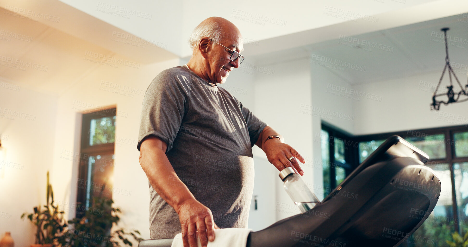 Buy stock photo Treadmill, water and watch with senior man in living room of home for exercise or fitness. Time, training and workout with old person walking on machine in apartment for cardio, challenge or progress