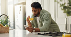 Home, internet and man in kitchen, smartphone and typing with social media, connection and email. Nutrition, orange juice and cellphone with communication, wellness and message to contact or chatting