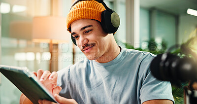 Buy stock photo Headphones, tablet and man in studio for podcast, broadcast and talk show at media agency. Radio producer, content creation and person on digital tech for planning script, interview or notes for host