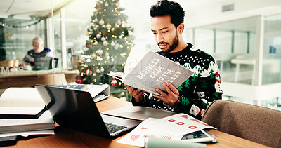 Statistics, research and man in office with book on business guide to the galaxy for information. Laptop, Christmas and male financial manager with documents for investment graphs, data or charts.