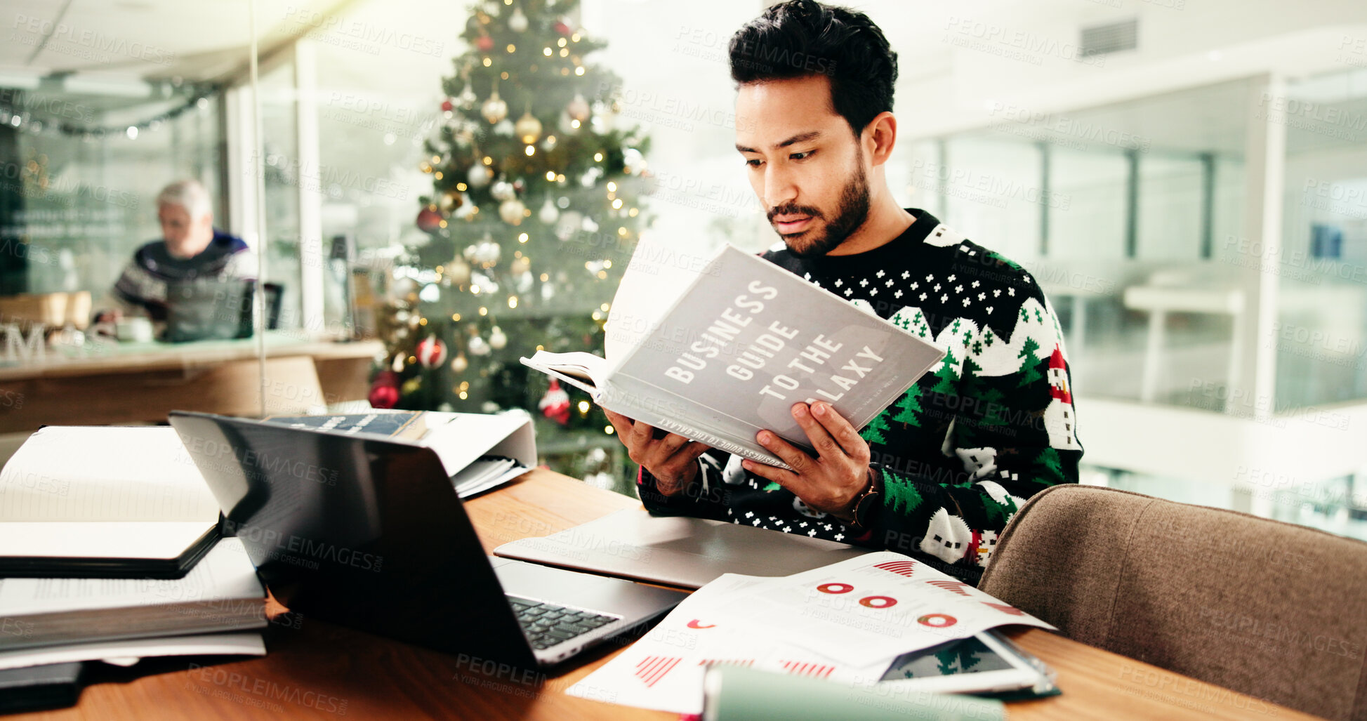 Buy stock photo Statistics, research and man in office with book on business guide to the galaxy for information. Laptop, Christmas and male financial manager with documents for investment graphs, data or charts.
