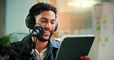 Buy stock photo Live streaming, influencer and man with mic, tablet and read script for episode or content creation. Happy, podcaster and person with tech for entertainment, online and headphones for audio in studio