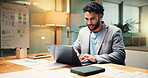 Businessman, financial analyst or typing with laptop at night for company report in office. Man, accountant or finance advisor working late with computer or documents for budget review in workplace