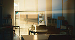 Empty classroom, desk and chairs for education at college with lens flare, glass board and table in hall. Room, campus and furniture at venue for scholarship, development and interior at university