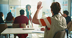 Student, man and raised hand in classroom at university with learning, notes and question for education. Person, back and attention with scholarship, gesture and solution with discussion at college
