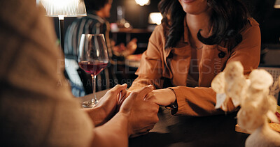 Buy stock photo Holding hands, date and love with couple in restaurant for romantic anniversary, bonding and fine dining chat. Connection, relax and marriage commitment with people at night for dinner and support