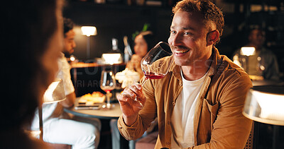 Buy stock photo Happy man, night and drinking with wine in restaurant for fine dining, dinner or anniversary in cafe. Male person, alcohol and glass with couple on date for romance, valentines day or evening out