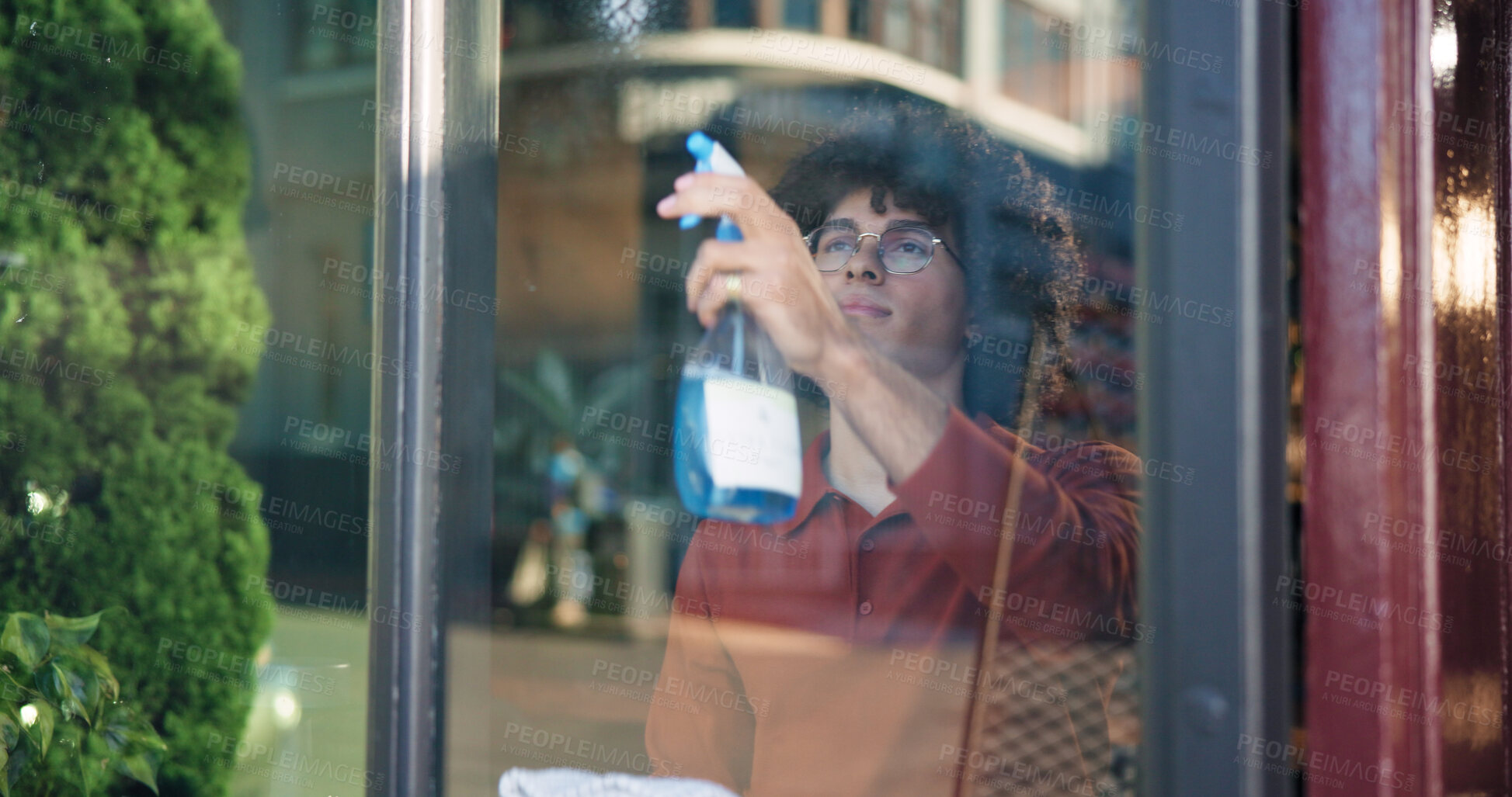 Buy stock photo Man, owner and cleaning with window in cafe for detergence, disinfectant or preparation. Male person, barista or bottle with glass, spray or chemical for dirt, bacteria or germ removal in coffee shop
