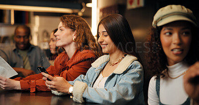 Buy stock photo Happy, friends and women with phone in restaurant for social media, message and networking. Nightclub, talking and people on smartphone for gathering, hangout and online dating app on weekend