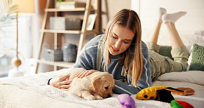 Buy stock photo Bed, playing and woman with puppy in home with smile for bonding, relationship and adoption. Happy, pet owner and person with Golden Retriever dog in bedroom with toys for relax, cuddle and care