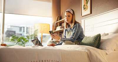 Buy stock photo Woman, student and phone with laptop on bed, texting and check notification with web chat in home. Girl, smartphone and computer for elearning, study or virtual course for college assessment in house