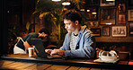 Business, man and typing on laptop at cafe for planning, research and feedback on article. Male person, pc and editing story, review schedule and proofreading information of publication at restaurant