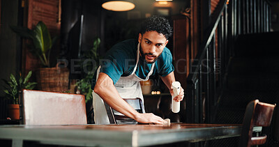 Buy stock photo Cleaning, spray bottle and wipe with man in coffee shop for disinfection, hospitality or hygiene. Bacteria, dirt and table with waiter in cafe or restaurant for maintenance of small business startup