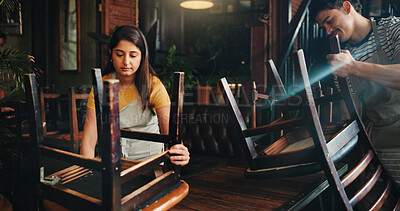 Buy stock photo People, waiter and arranging chairs at cafe for closing time, cleaning routine and space management. Man, waitress and teamwork for layout, reserved seating and out of service of hospitality industry