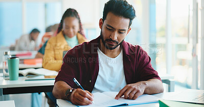 Buy stock photo Man, college student and writing with book in classroom for development, learning and scholarship. Person, notes and attention with project, assessment and education with solution at university