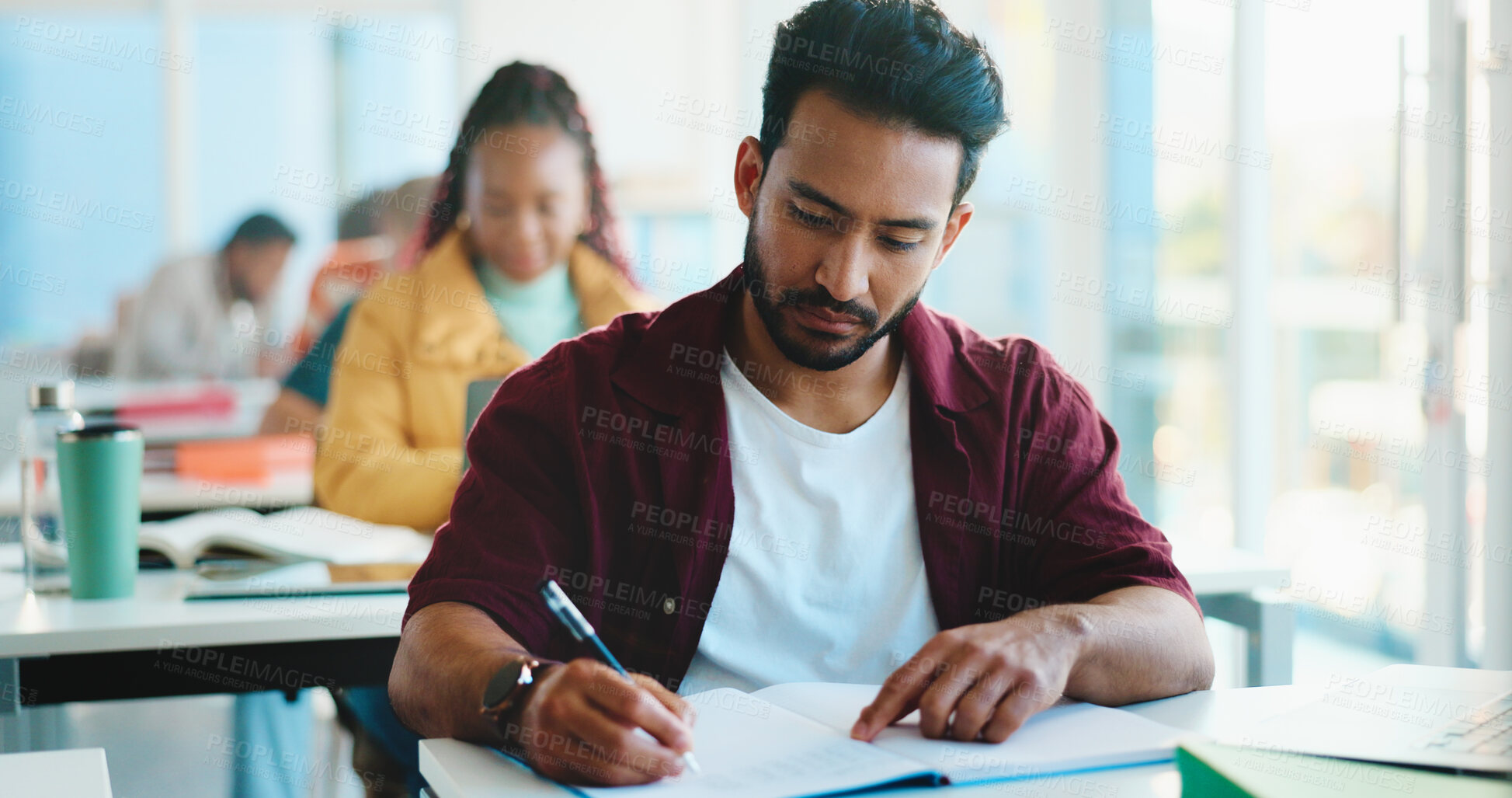 Buy stock photo Man, college student and writing with book in classroom for development, learning and scholarship. Person, notes and attention with project, assessment and education with solution at university