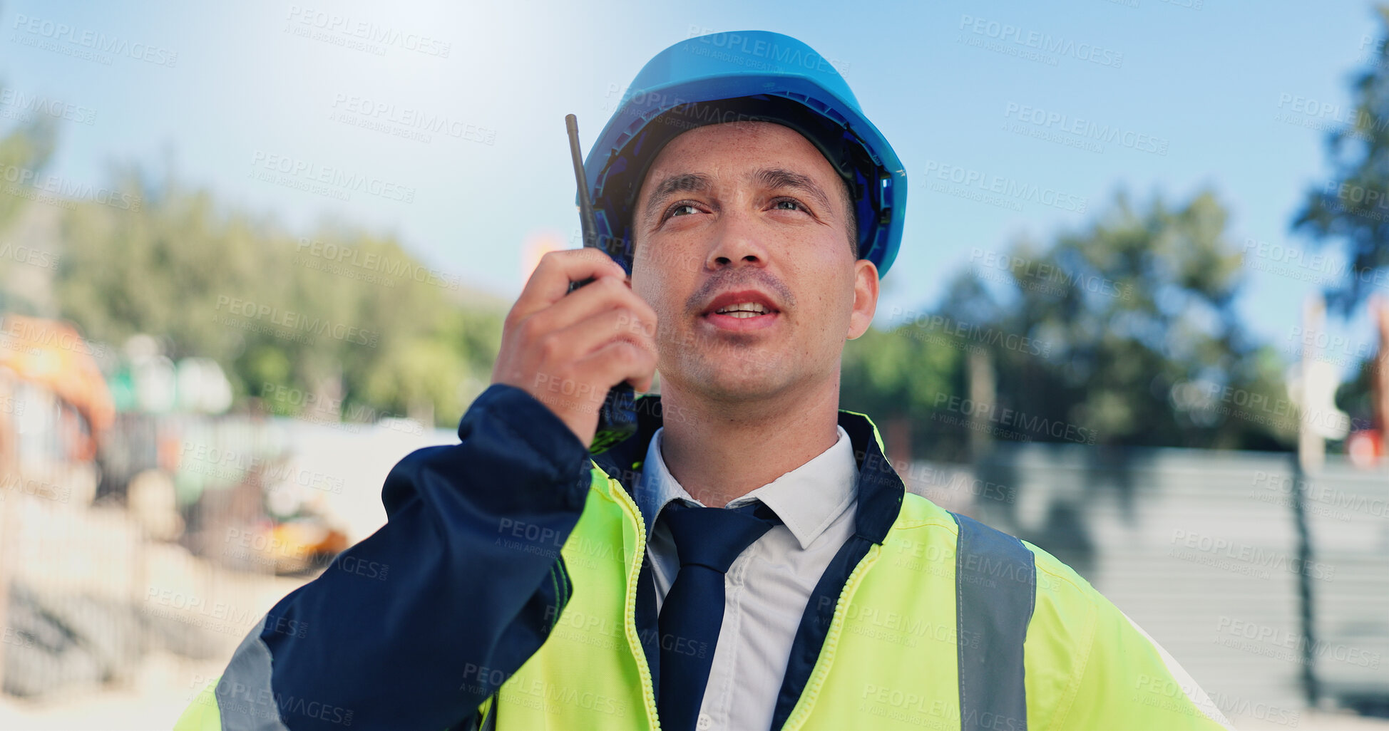 Buy stock photo Man, engineer and talk with radio at construction site with inspection, outdoor and property expansion. Person, architect and communication for real estate development, safety check or tech in Mexico
