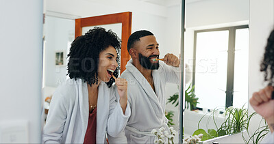Buy stock photo Happy couple, brushing teeth or mirror in bathroom for dental hygiene, wellness or morning in home. Man, woman or oral care with reflection or toothbrush for routine, mouth or gum protection in house