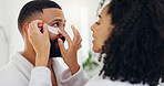 Couple, eye patches and help in bathroom for facial treatment, vitamin C or collagen in home. Man, woman or assistance with cosmetics, product or mask for beauty, health or wellness together in house