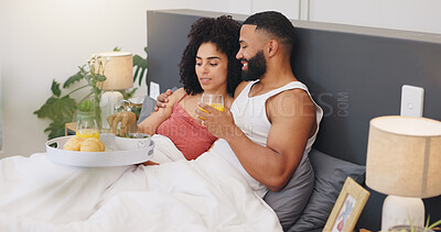 Buy stock photo Couple, relax and breakfast in bed with love, honeymoon trip or smile for room service in hotel. Happy man, woman and juice in bedroom with comfort, nutrition or vacation stay at luxury accommodation
