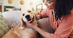 Woman, dog and happy on sofa, relax and bonding with care, connection and stroke in living room. Person, touch and comfort for pet, golden retriever or love for cuddle on couch in lounge at apartment