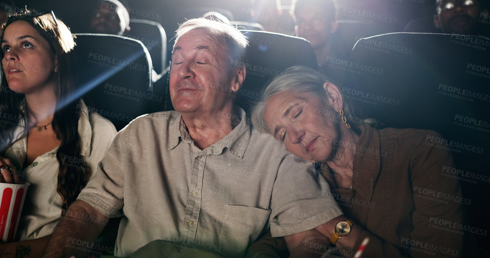 Buy stock photo Senior couple, date and sleep at movie theater in crowd, bonding or tired with rest at show in. Exhausted elderly people, relax together and love with fatigue, embrace and film screening at cinema