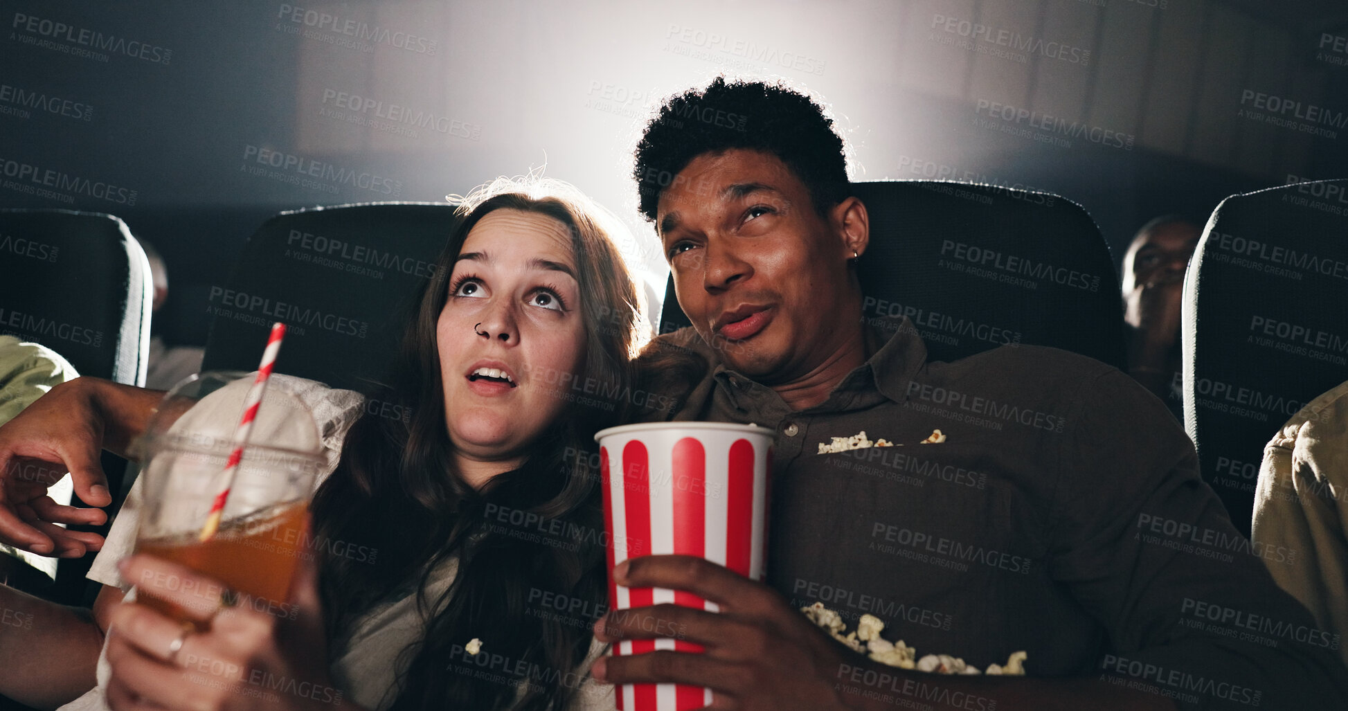 Buy stock photo Couple, popcorn and suspense movie at theater with snack, date and entertainment at film screening. People, man and woman with shock for thriller in crowd, spooky show or scared with horror at cinema