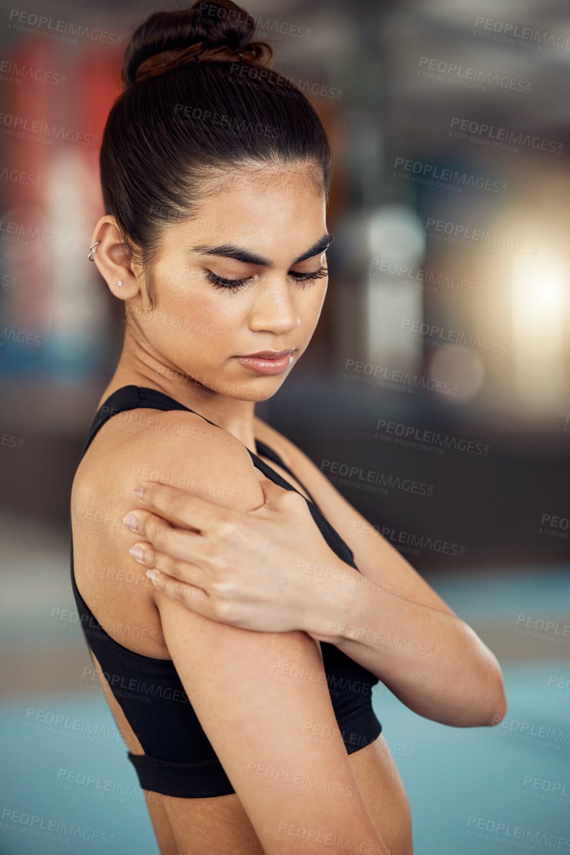 Buy stock photo Injury, hurt and shoulder pain for a female athlete holding her painful arm at the gym. Active, fit and athletic woman suffering from muscle inflammation due to an exercise or workout