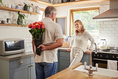Buy stock photo Senior, couple and flowers for love in kitchen, husband with bouquet of roses to wow wife, happy and marriage on wedding anniversary. Man, flowers and woman together, romance and surprise in home