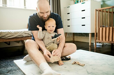 Buy stock photo Child, preparing and father dressing kid with shoes and getting ready at home in a bedroom and bonding together. Single dad, baby and man helping his young son change clothes as support, care or love