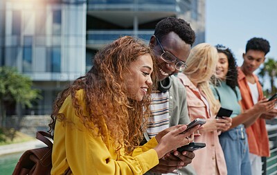 Buy stock photo Group, students and happy with phone at university, campus or laughing for diversity, learning or development. Gen z friends, women and men on mobile app, web chat and meme on social media at college