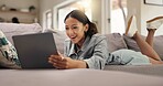 Happy woman, student or good news with laptop on sofa for college application or acceptance at home. Female person, smile or lying with computer on couch for academic result or online course at house