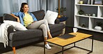 Happy, woman and relax by watching tv at house for peace, movie and subscription service on couch. Smile, female person and chilling with thoughts while streaming film, surfing show and entertainment