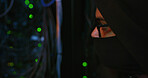 Night, hacker and person with mask by cables for scam, phishing or cybercrime for online attack. Anonymous, privacy and programmer with security breach, server or database encryption in control room.