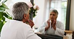 Home, mirror and old woman with skincare, stress and dermatology with anti aging. Pensioner, beauty and elderly person with wellness, reflection and grooming with morning routine, worry and wrinkles
