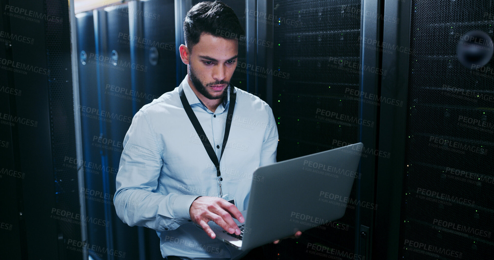 Buy stock photo Data center, cybersecurity and man with laptop, typing and  network engineer with tech for software. Server room, IT specialist and person with computer for firmware upgrade, serious and maintenance