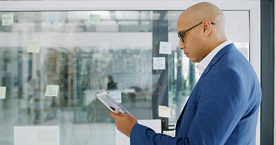 Buy stock photo Businessman, tablet and reading for finance, research or brainstorming in office for strategy. Glass wall, employee and technology with sticky note, feedback or schedule tasks for investment project