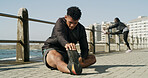 Man, fitness and stretching with leg for workout preparation or flexibility on promenade. Active, male person or runner with body warm up or foot for physical exercise or outdoor training on sidewalk