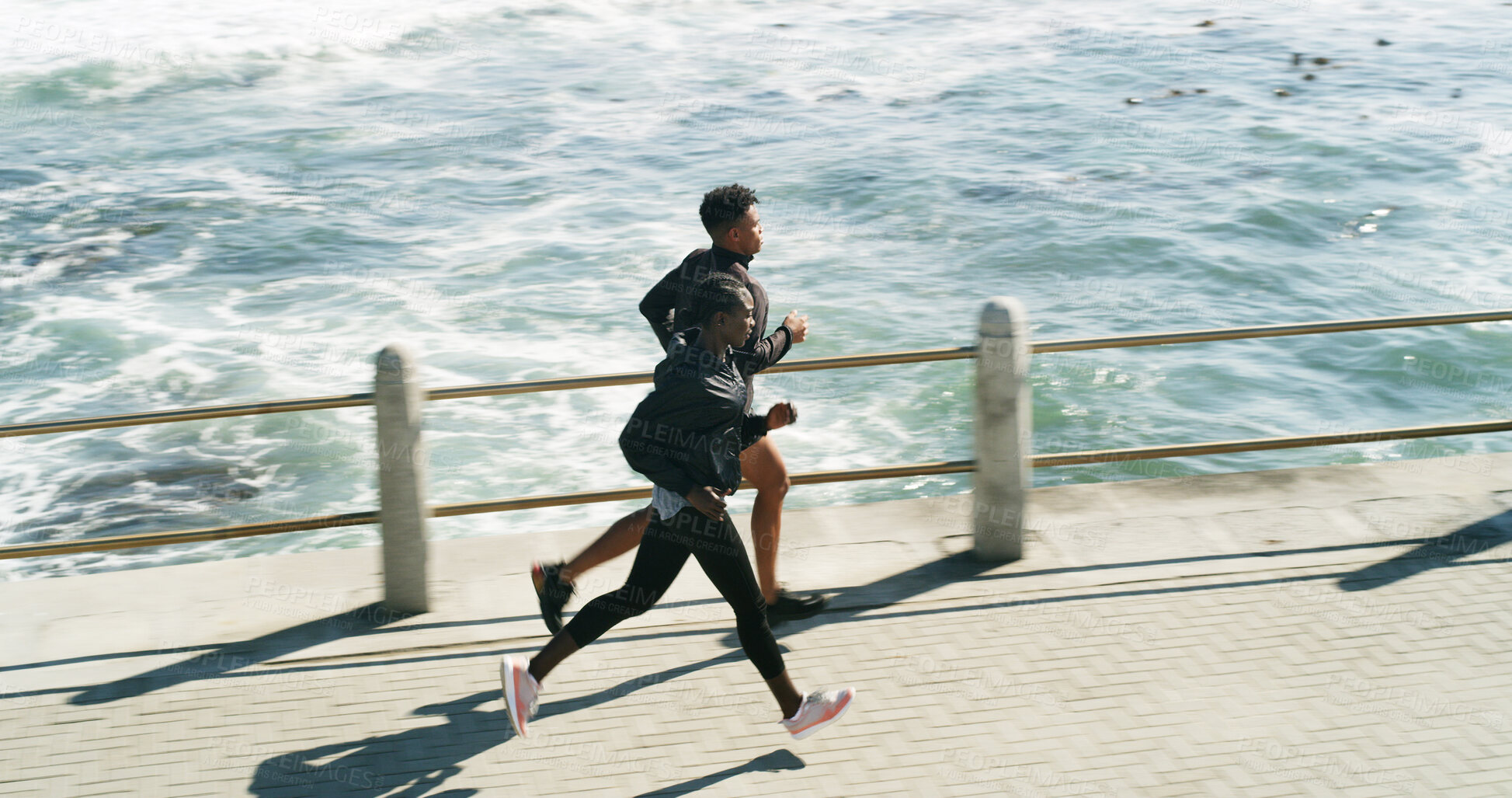 Buy stock photo Workout, people and running at beach promenade for burning calories, endurance or cardio routine. Above, athlete or trainer jogging at ocean for pace training, marathon exercise or fitness challenge