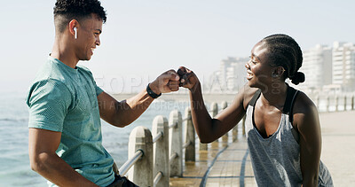 Buy stock photo Happy couple, fitness and beach with fist pump for teamwork, workout goals or done on promenade. Active, man and woman with smile or touch on ocean coast for finished exercise or success together