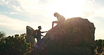 Cliff, hiking and support with couple in nature for trekking, adventure and summer vacation. Explore, backpacking and mountain summit with people outdoor for sunrise, freedom and holiday tourism