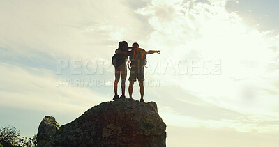 Buy stock photo Couple, hiking and point on rock, mountain and hug with back, low angle and sky on tourism adventure. People, view and outdoor for trekking, direction or landmark on embrace on cliff in summer