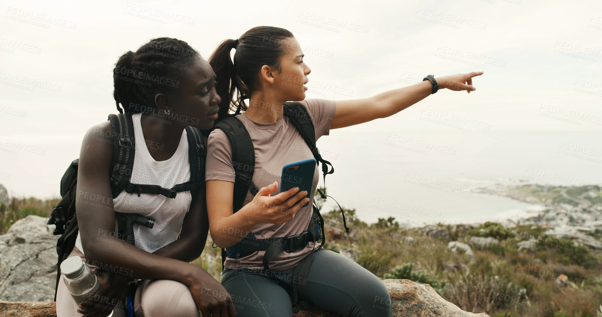 Buy stock photo Girl, friends and hiking with phone on mountain, talk or point with digital map on trail. Women, discussion and smartphone for route, trekking and app for adventure, location or landmark in summer