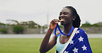 Runner, woman and medal with USA flag, bite or excited for success with goals at global competition. Girl, athlete and champion with national pride, achievement or sports contest at stadium in summer